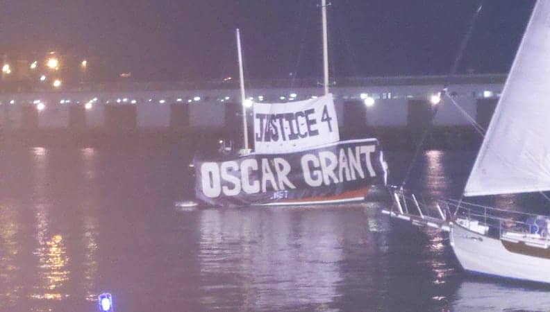 Justice-for-Oscar-Grant-banner-on-boat-in-McCovey-Cove-100710-at-night-by-Dave-Id-Indybay, Longshoremen will shut down all Bay Area ports Saturday to win justice for Oscar Grant, Local News & Views 