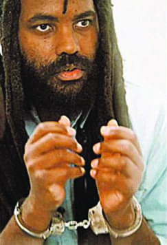 Mumia-in-handcuffs-looking-up-color, Two messages from Mumia – from a week ago and from 1981, Abolition Now! 