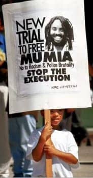Mumia-sign-New-Trial-to-Free-Mumia-carried-by-little-boy, Two messages from Mumia – from a week ago and from 1981, Behind Enemy Lines 