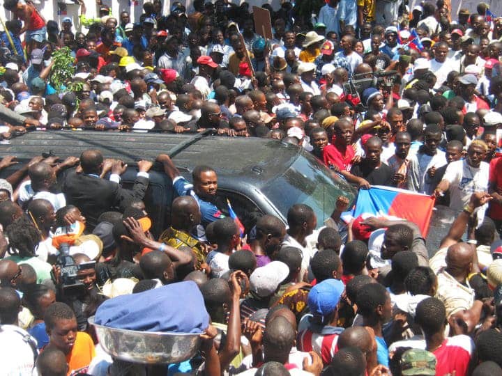 Haitians-surround-Aristides-car-from-airport-to-home-031811-by-Jean-Ristil-Jean-Baptiste, Pierre Labossiere on welcoming Aristide home to Haiti, World News & Views 