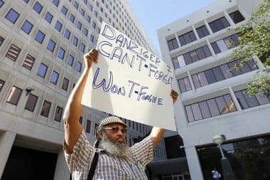 New-Orleans-Danziger-Bridge-trial-W.C.-Johnson-of-Community-United-for-Change-protests-0611-by-Gerald-Herbert-AP, Six years after Katrina, the battle for New Orleans continues, News & Views 