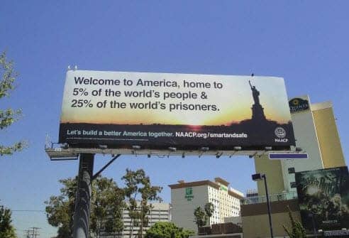 California-billboard-‘Welcome-to-America-home-to-5-of-the-world’s-people-25-of-the-world’s-prisoners’-2011-by-NAACP, Alternatives to Jerry Brown’s ‘more cages’ prison plan proposed, Abolition Now! 