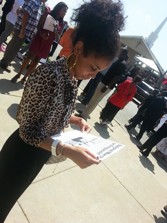 Michael-Brown-funeral-young-woman-reading-flier-St.-Louis-082514-by-JR-BR, Thousands attend funeral of Michael Brown, News & Views 