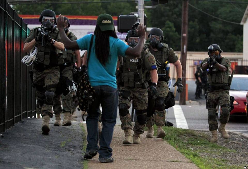 Michael-Brown-murder-aftermath-white-cops-in-riot-gear-aim-gun-at-Black-man-hands-raised-Ferguson-Mo-081114-by-AP-VOA1, To win justice for Michael Brown, send the Black press to Ferguson, Missouri, News & Views 