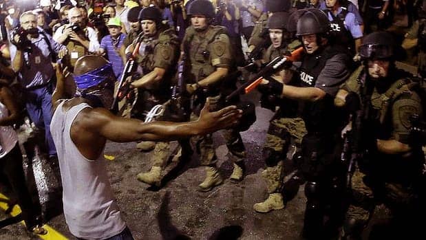 Michael-Brown-rebellion-young-man-confronts-riot-cops-aiming-guns-at-him-091914-by-AP, Mumia on the meaning of Ferguson, News & Views 