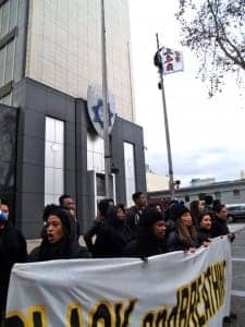 ShutdownOPD-Black-contingent-chants-flagpole-climber-unfurls-BlackLivesMatter-121514-by-BaySolidarity-web-225x300, Protesters shut down Oakland Police Department for almost 4.5 hours today, demand end to police aggression against Black people, Local News & Views 