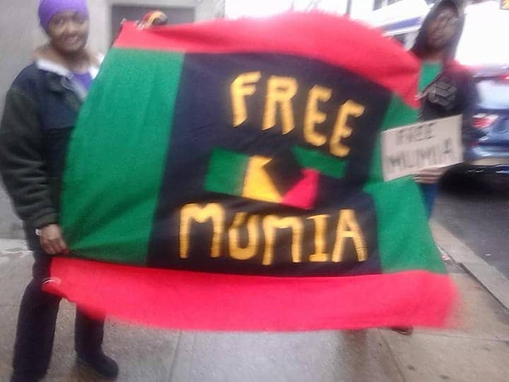 Free-Mumia-banner-PA-DOC-Dir-Wetzels-office-040315, Mumia’s life is in danger; only the people can save him – keep calling!, Behind Enemy Lines 