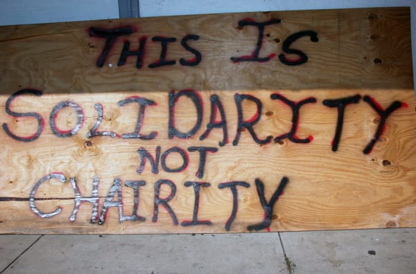 This-is-solidarity-not-charity-sign-outside-1st-Common-Ground-Health-Clinic-071405-by-Bradley-Indymedia, ‘Katrina: After the Flood’, News & Views 