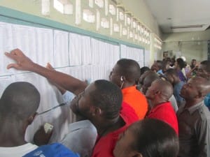 Haiti-election-day-Petionville-voters-search-for-their-ID-number-prior-to-voting-102515-by-John-Carroll-300x225, Fact finding delegation reports an electoral coup now in process in Haiti, World News & Views 