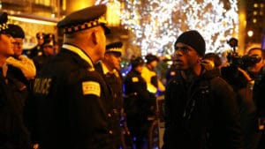 Laquan-McDonald-protester-stares-down-Chicago-police-112415-by-Chicago-Tribune-web-300x169, #LaquanMcDonald: As video released, cop charged with murder 1, activists demand Police Supt. McCarthy, State’s Attorney Alvarez resign, News & Views 