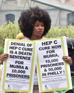 March-for-Mumia-to-govs-ofc-demanding-Hep-C-cure-Black-woman-w-posters-042216-Philly-by-Joe-Piette-240x300, Is there a balm in Gilead?, News & Views 