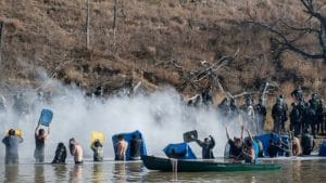 Standing-Rock-police-pepper-spray-water-protectors-crossing-river-to-land-owned-by-pipeline-co.-110216-by-Reuters-300x169, Standing Rock: Water cannons fired at water protectors in freezing temperatures injure hundreds, News & Views 