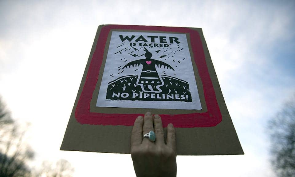 Water-is-Sacred-No-Pipelines-Native-hand-holding-sign-0217-by-London-Guardian, Wherever you are, you too can strike a blow against the Dakota Access Pipeline, News & Views 