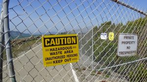 Caution-Hazardous-Waste-Area-Unauthorized-Persons-Keep-Out-sign-on-fence-Treasure-Island-by-Carol-web-300x169, Death camp Treasure Island, Local News & Views 