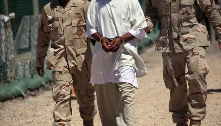 Guantanamo-Black-prisoner-escorted-by-guards-by-CNN, Guantanamo Bay is hell on earth: an interview wit’ journalist Adam Hudson, Abolition Now! 