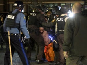 Ferguson-man-arrested-for-kneeling-in-street-outside-Ferguson-PD-112914-by-Jeff-Roberson-AP-300x225, Why we won’t wait: Resisting the war against the Black and Brown underclass, News & Views 