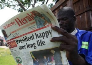 Zimbabwe-man-reads-Herald-on-Mugabes-91st-birthday-022115-by-Tsvangirayi-Mukwazhi-AP-300x213, At 91, President Mugabe leads Zimbabwe, SADC and African Union – with vigor, World News & Views 