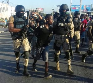 Haiti-election-protest-masked-police-arrest-protester-1216-by-HIP-web-300x268, Resisting the lynching of Haitian liberty!, World News & Views 