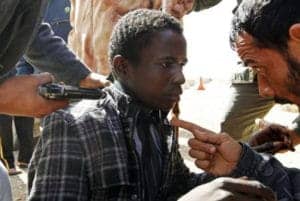 Anti-Qaddafi-forces-threaten-young-Black-African-Libya-between-towns-Brega-Ras-Lanuf-030311-by-Goran-Tomasevic-Reuters-300x201, Deceptive intelligence: CNN breaks story on slave trade in Libya, World News & Views 
