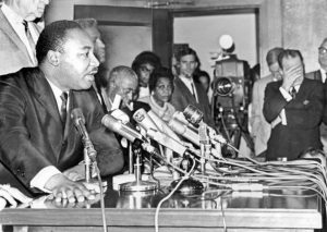Martin-Luther-King-says-LAPD-Chief-Wm.-H.-Parker-shd-resign-after-65-Watts-Rebellion-as-Mayor-Sam-Yorty-covers-face-press-conf-LA-City-Hall-081965-by-Larry-Sharkey-LA-Times-300x213, Acting Mayor London Breed honors Dr. King and reports progress in supporting homeless and immigrant San Franciscans, Local News & Views 