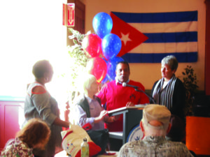 Dr.-Luis-Heredia-Guerra-of-Cuba-speaks-at-Downtown-Oakland-Senior-Center-director-Jennifer-King-at-left-1218-by-Jahahara-300x225, Four hundred years, 5859-6259 AAC (1619-2019 JC-PG): ‘James-town,’ the ‘13 colonies,’ ucptsa and Africans’ freedom, Culture Currents 