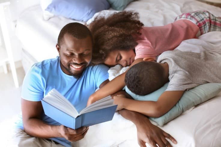 Black-dad-reads-to-children-in-bed, Kids, adversity and sleep problems: What you can do, Culture Currents 
