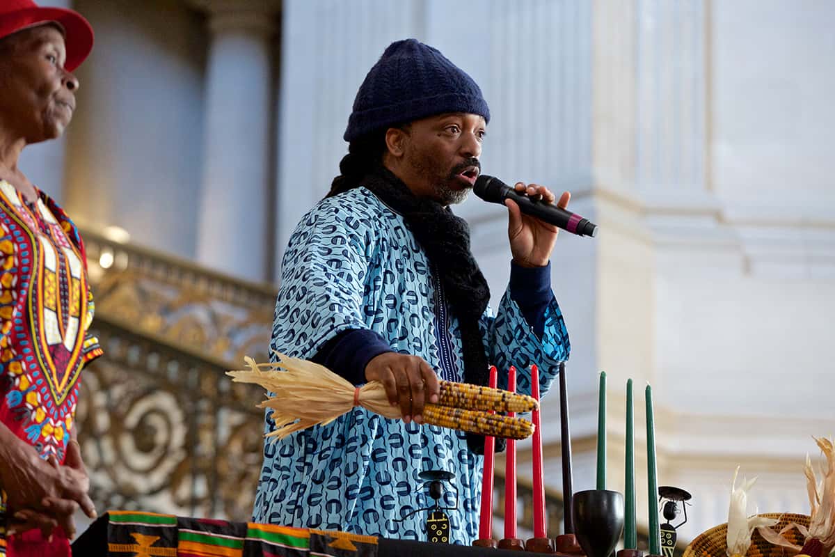 Kwanzaa-SF-City-Hall-Adrian-Williams-Village-Project-Malik-Seneferu-explains-symbols-122618-by-Kevin-Hume-SF-Examiner, Let’s have a fruitful Kwanzaa!, Culture Currents 