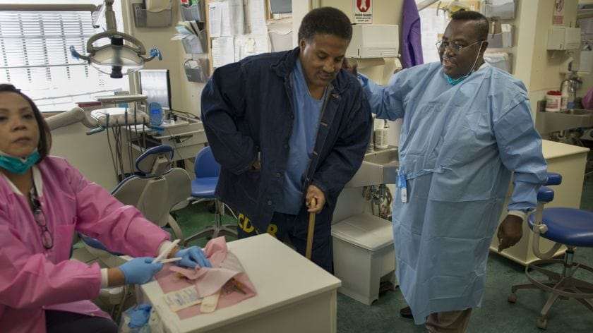 Dentist-Opanin-Gyaami-treats-incarcerated-patient-Larry-Butler-at-the-California-Medical-Facility-in-Vacaville-2012-by-David-Butow-LA-Times, More testing is needed to protect prisoners and caregivers, Abolition Now! 