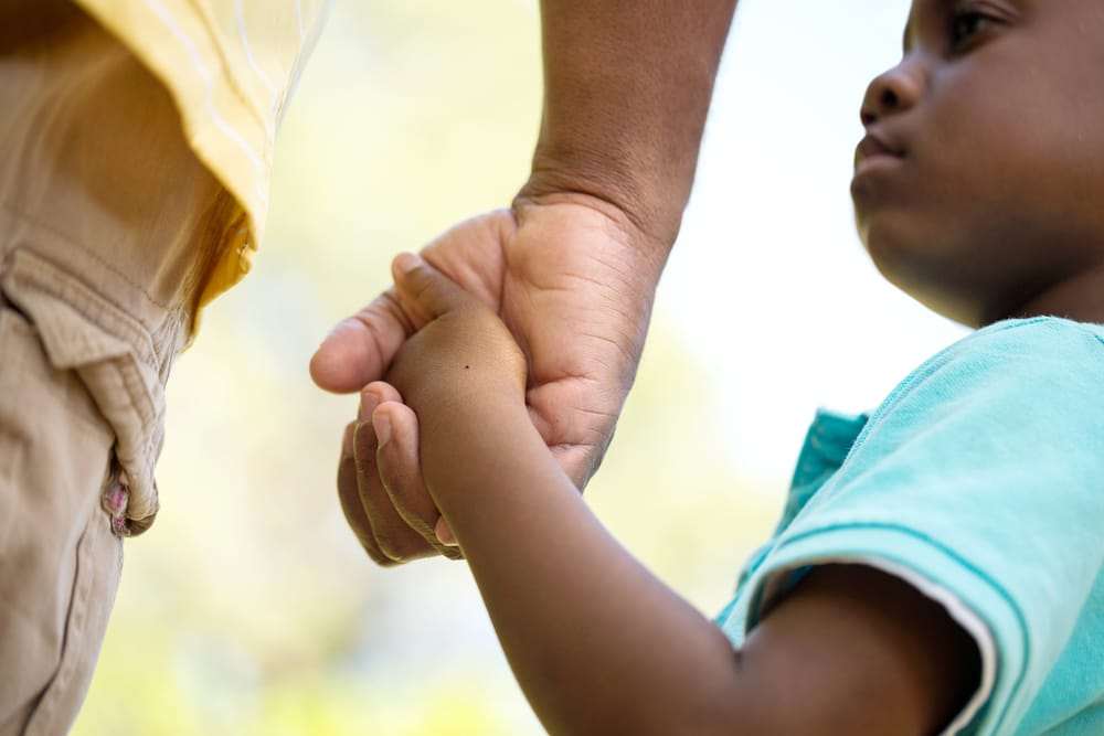 Lil-Black-child-holds-adult-hand, Having ‘The Talk’ with your children in the era of Black Lives Matter, Culture Currents 