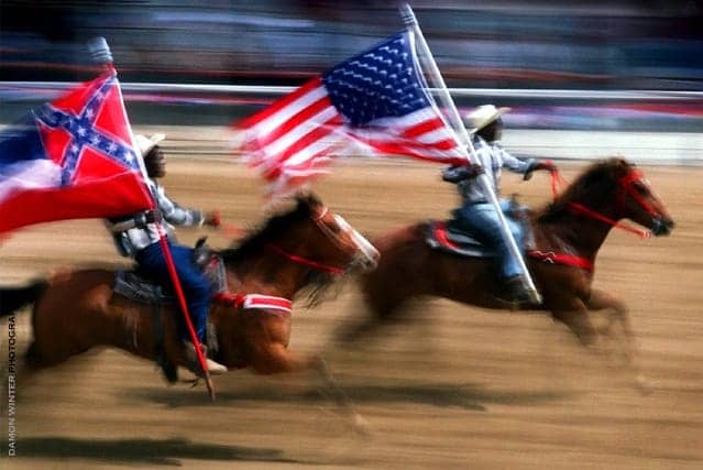 Angola-Prison-Rodeo-Black-prisoner-carries-Mississippi-state-flag-w-Confederate-battle-flag-2009-by-Damon-Winter-Photography, The Angola gulag, Behind Enemy Lines 