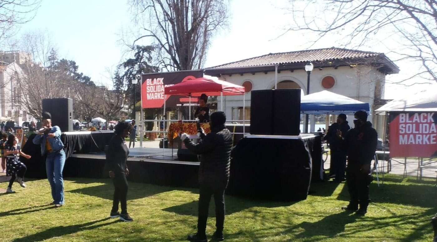 Queen-Emcee-Ryan-Nicole-Austin-spits-consciousness-with-DJ-Ryan-at-CRCs-Black-Solidarity-Market-at-Lake-Merritt-Oakland-by-Jahahara-1400x777, Commemorating International Workers’ and African Liberation days, Culture Currents 