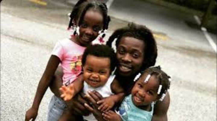 Ozone-aka-Othal-Wallace-hugs-his-babies, Manhunt: Freedom fighter Ozone charged with murdering cop, News & Views 