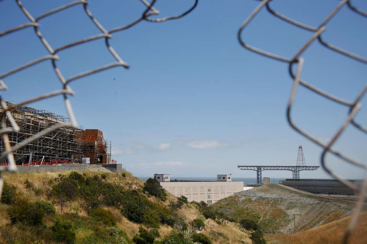 View-of-Hunters-Point-Shipyard-new-condos-NRDL-Bldg-815-gantry-crain-through-hole-in-fence-103018-by-Lea-Suzuki-SF-Chronicle, Quest to detect plutonium, Local News & Views 