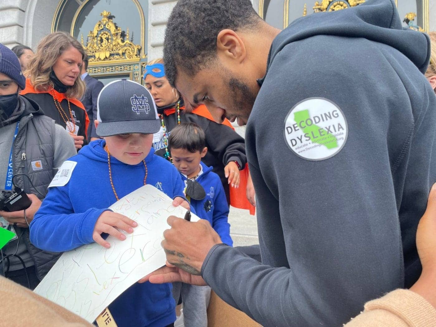 Golden-State-Warriors-guard-Gary-Payton-II-signing-at-Decoding-Dyslexia-CA-rally-in-San-Francisco-at-City-Hall-by-Daphne-Young-032922-1400x1050, Golden State Warriors guard rallies for dyslexia screenings, Culture Currents News & Views 
