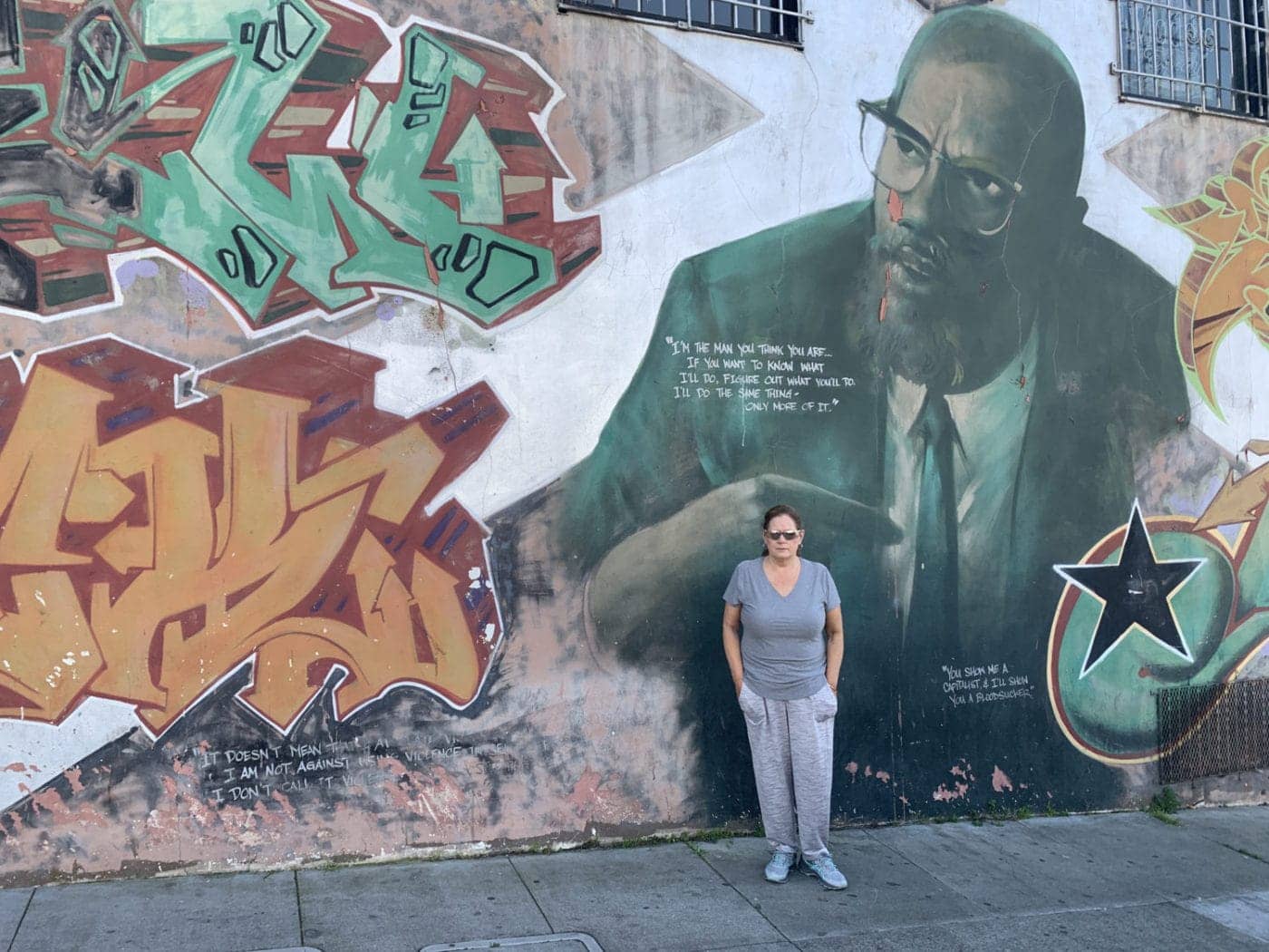 Kelly-at-the-Malcolm-X-mural-Bayview-SF-22022-1400x1050, T.H.U.G L.I.F.E: From gangster to growth, Abolition Now! 