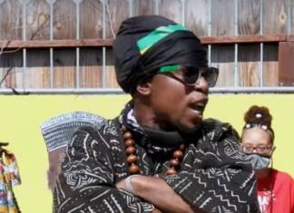 California prison officials label Minister King X a ‘Black Supremacist Extremist’ – King fights back Minister King X standing with his arms crossed. Wearing African male attire, black and white weave pattern.