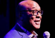 Man in royal blue suit facilitating event.