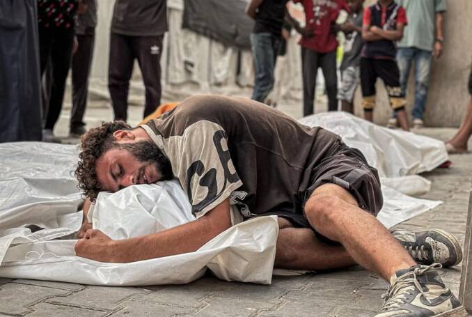 gazan-man-lies-in-street-embracing-body-wrapped-for-burial-by-ali-attar-social-media, Forgive me, Gaza: Humanity has not learned from its sins, News & Views World News & Views gazan-man-lies-in-street-embracing-body-wrapped-for-burial-by-ali-attar-social-media, Forgive me, Gaza: Humanity has not learned from its sins, News & Views World News & Views