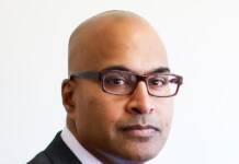 We can’t claim to value justice while starving public defense African American Male wearing down classes and a blue suit and tie with a white shirt.