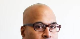 We can’t claim to value justice while starving public defense African American Male wearing down classes and a blue suit and tie with a white shirt.