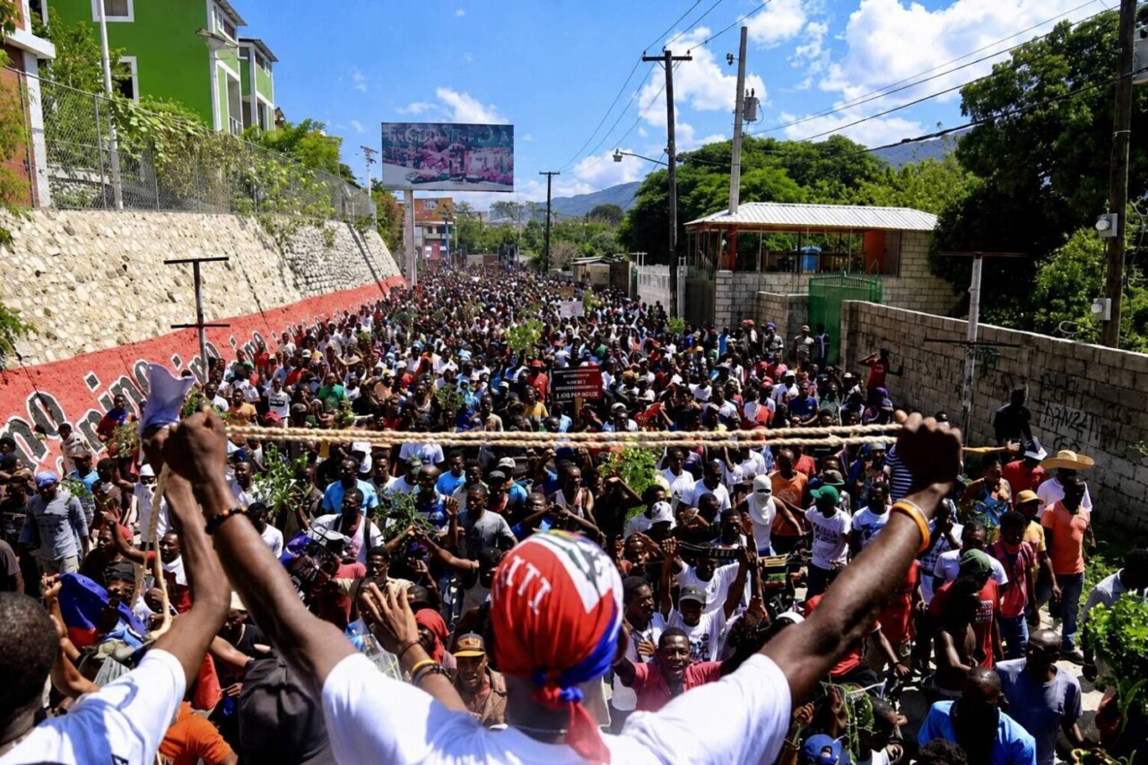 haitian-man-stands-before-a-crowd-holding-a-rope, Haiti: solidarity in a world at war, Featured World News & Views haitian-man-stands-before-a-crowd-holding-a-rope, Haiti: solidarity in a world at war, Featured World News & Views