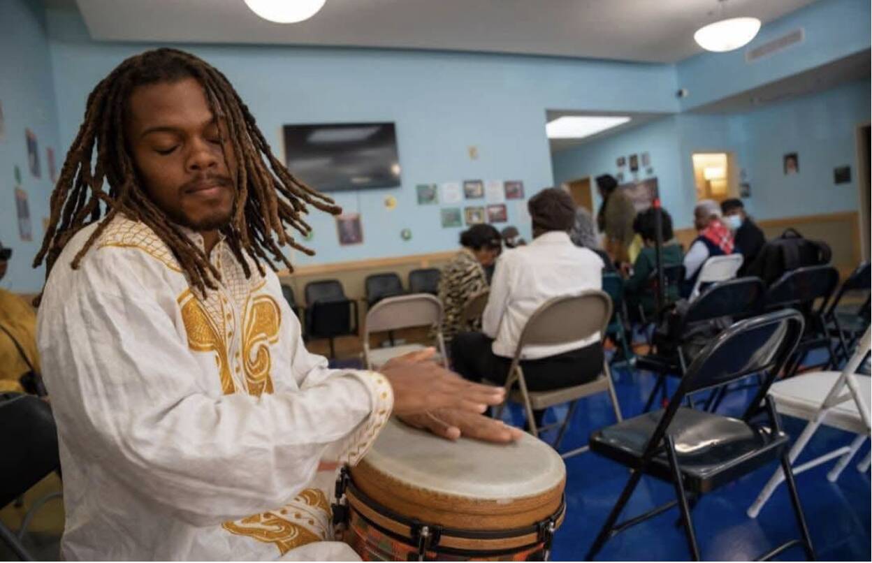 sol-charge-black-man-playing-drum-in-blue-room-with-dreadlocks, Sol Charge - Resting in Power, Culture Currents Featured 
